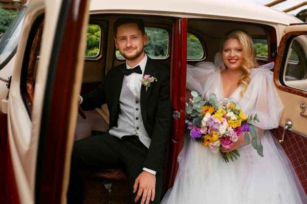 medium-shot-couple-posing-vintage-car_23-2150327204